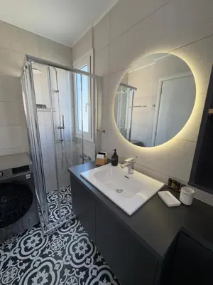 a bathroom with a sink and a mirror and a shower at Acropolis Golden View Penthouse in Athens