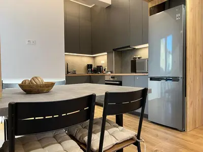 a kitchen with a table and a refrigerator at Acropolis Golden View Penthouse in Athens