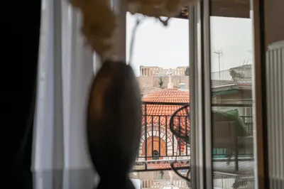 a cat looking out of a window at a building at Acropolis Golden View Penthouse in Athens