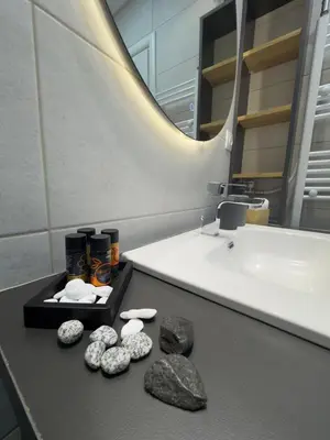 a bathroom with rocks on a counter next to a sink at Acropolis Golden View Penthouse in Athens