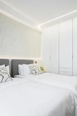 two beds in a white bedroom with white walls at Deluxe Apartment in Kallithea with Balcony & Wifi in Athens