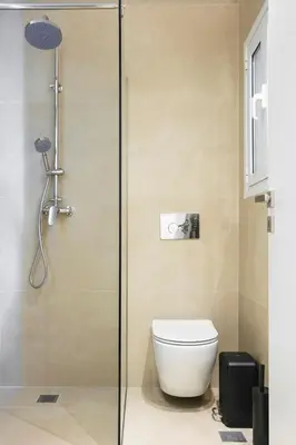 a bathroom with a toilet and a glass shower at Deluxe Apartment in Kallithea with Balcony & Wifi in Athens
