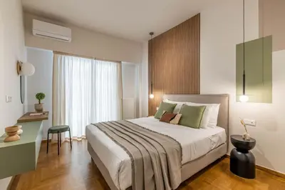 a bedroom with a bed with a desk and a window at Urban Elegance 2BR Apartment in Pangrati by UPSTREET in Athens