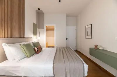 a bedroom with a large white bed with green pillows at Urban Elegance 2BR Apartment in Pangrati by UPSTREET in Athens