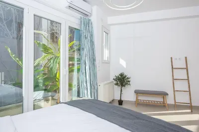 a bedroom with a bed and a large window at The Place to Be Kastella Exclusive in Piraeus