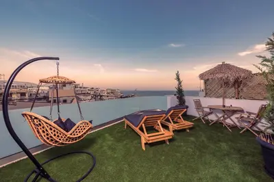 a patio with chairs and tables on a roof at The Place to Be Kastella Exclusive in Piraeus