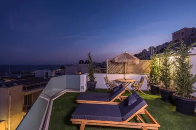 a balcony with chairs and a table on a roof at The Place to Be Kastella Exclusive in Piraeus