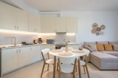 a kitchen and living room with a table and chairs at The Place to Be Kastella Exclusive in Piraeus