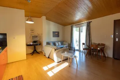 a living room with a couch and a table at RELAXING POOL HOUSE IN LAGONISI 2 in Kalívia Thorikoú