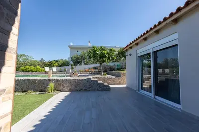 a patio of a house with a stone wall at RELAXING POOL HOUSE IN LAGONISI 2 in Kalívia Thorikoú