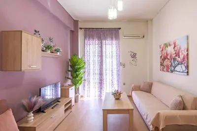 a living room with a couch and a tv at Sweet home in Zografou in Athens