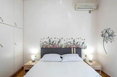 a bedroom with a large white bed with two white pillows at Sweet home in Zografou in Athens