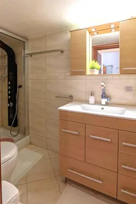 a bathroom with a sink and a toilet and a mirror at Sweet home in Zografou in Athens