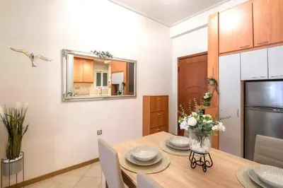 a kitchen and dining room with a table and a refrigerator at Sweet home in Zografou in Athens