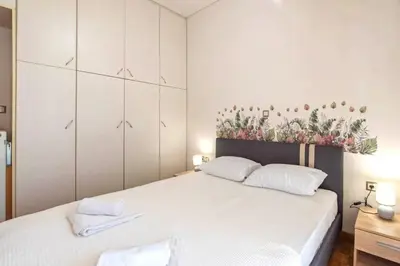 a bedroom with a large white bed with two white pillows at Sweet home in Zografou in Athens