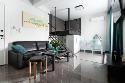 a living room with a black couch and a table at Smart-Stay Acropolis View in Athens