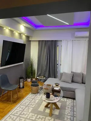 a living room with a white couch and a tv at Maria's luxury apartment in Athens