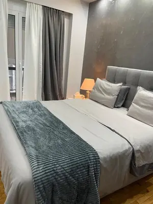 a bedroom with a large bed with a blanket on it at Maria's luxury apartment in Athens