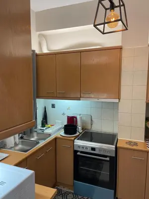 a kitchen with wooden cabinets and a stove top oven at Maria's luxury apartment in Athens