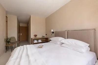 a large white bed with white pillows in a bedroom at Regal Hotel Mitropoleos in Athens