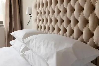 a bedroom with a white bed with a padded headboard at Regal Hotel Mitropoleos in Athens