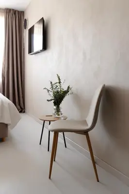 a chair and a table with a vase of flowers at Regal Hotel Mitropoleos in Athens