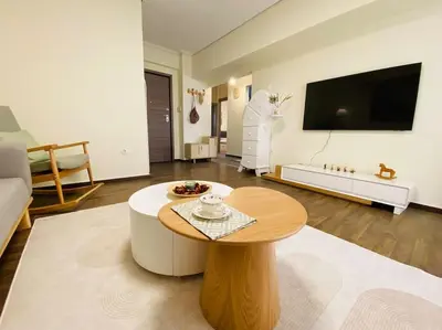 a living room with a coffee table and a flat screen tv at \u5730\u94c1\u7ad9\u65c1\uff0c\u514d\u8d39\u505c\u8f66\uff0c\u5b89\u9759\u8212\u9002\u8857\u533a\uff0c\u7cbe\u54c1\u4e24\u5367\u5ba4\u5927\u9732\u53f0\u516c\u5bd3\uff0c\u6cbb\u5b89\u597d in Athens
