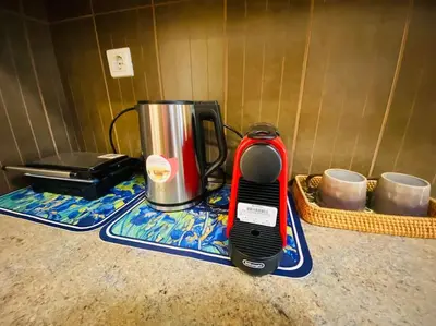 a red and black appliance sitting on a kitchen counter at \u5730\u94c1\u7ad9\u65c1\uff0c\u514d\u8d39\u505c\u8f66\uff0c\u5b89\u9759\u8212\u9002\u8857\u533a\uff0c\u7cbe\u54c1\u4e24\u5367\u5ba4\u5927\u9732\u53f0\u516c\u5bd3\uff0c\u6cbb\u5b89\u597d in Athens