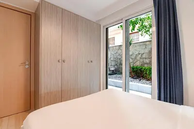 a bedroom with a bed and a large window at Quiet simple brand new luxury apartment by the sea in Athens