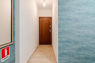 a hallway with a door in a room with blue paint at Quiet simple brand new luxury apartment by the sea in Athens