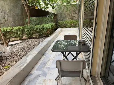 a table and chairs sitting on a patio at Quiet simple brand new luxury apartment by the sea in Athens