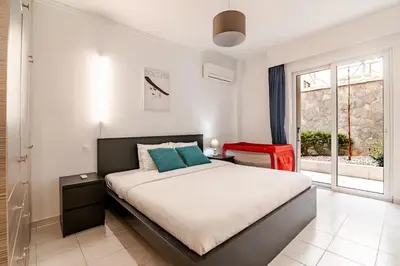 a bedroom with a large bed and a window at Quiet simple brand new luxury apartment by the sea in Athens