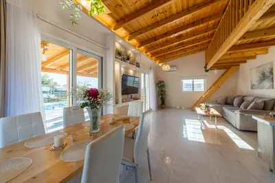 a living room with a table and a couch at RELAXING POOL HOUSE IN LAGONISI 1 in Kalívia Thorikoú