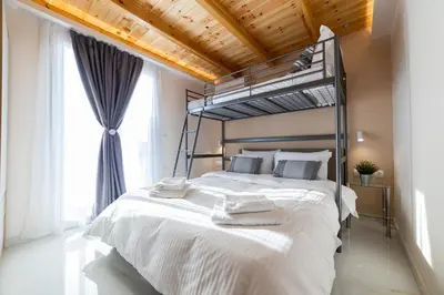 a bedroom with a large white bed with a metal canopy at RELAXING POOL HOUSE IN LAGONISI 1 in Kalívia Thorikoú
