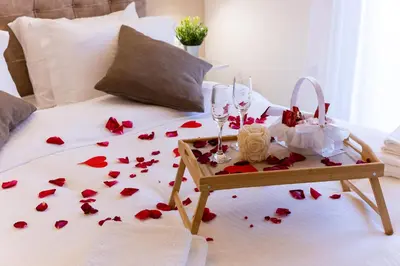 a bed with red roses and wine glasses on it at RELAXING POOL HOUSE IN LAGONISI 1 in Kalívia Thorikoú