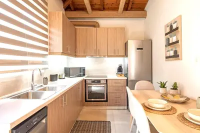 a kitchen with wooden cabinets and a stainless steel refrigerator at Stunning and spacious apt in Athens in Athens