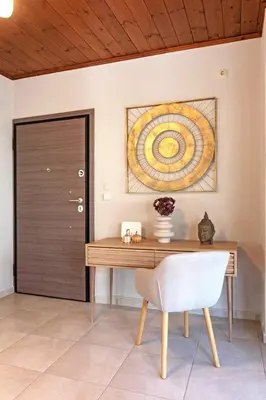 a wooden desk with a chair and a painting on the wall at Stunning and spacious apt in Athens in Athens