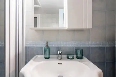 a bathroom sink with two bottles and glasses on it at Vintage 1BR in Exarchia Timeless in Athens