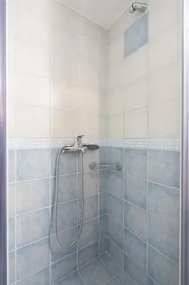 a bathroom with a shower with blue and white tiles at Vintage 1BR in Exarchia Timeless in Athens