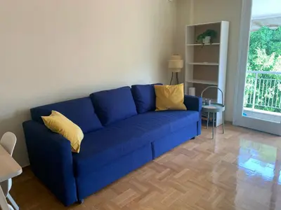 a blue couch with yellow pillows in a living room at Charming Plaka Retreat in the Heart of Historic old Athens city in Athens