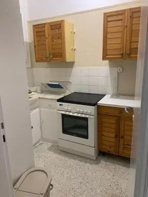 a kitchen with a white stove and wooden cabinets at Charming Plaka Retreat in the Heart of Historic old Athens city in Athens