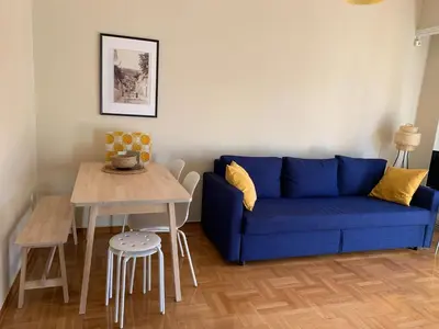 a living room with a blue couch and a table at Charming Plaka Retreat in the Heart of Historic old Athens city in Athens