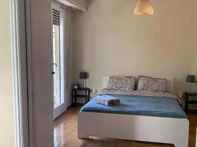 a bedroom with a bed with blue sheets and a window at Charming Plaka Retreat in the Heart of Historic old Athens city in Athens