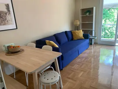 a living room with a blue couch and a table at Charming Plaka Retreat in the Heart of Historic old Athens city in Athens