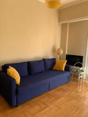 a blue couch with yellow pillows in a living room at Charming Plaka Retreat in the Heart of Historic old Athens city in Athens