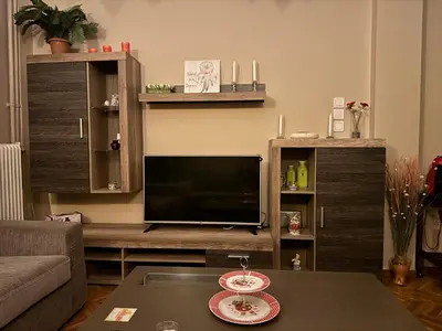 a living room with a tv and a table at Fully furnished apartment in the heart of Athens in Athens