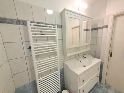 a white bathroom with a sink and a toilet at Kavouri Seaside 85sqm Apartment 5' from the beach in Athens