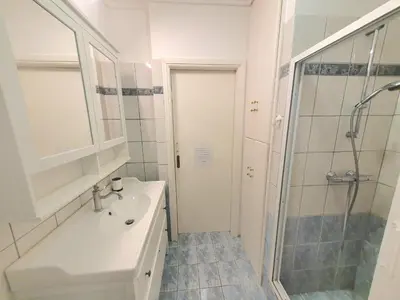 a white bathroom with a sink and a shower at Kavouri Seaside 85sqm Apartment 5' from the beach in Athens