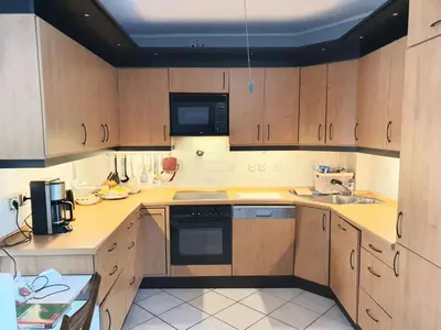 a kitchen with wooden cabinets and a sink at Kavouri Seaside 85sqm Apartment 5' from the beach in Athens