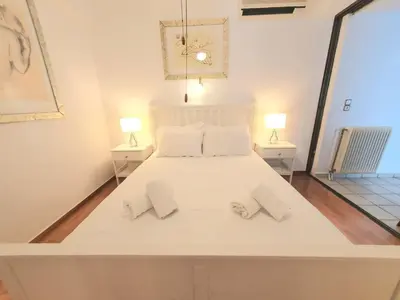 a large white bed in a room with two lamps at Kavouri Seaside 85sqm Apartment 5' from the beach in Athens